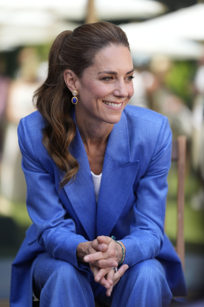 Kate Middleton sitting and smiling in a blue suit